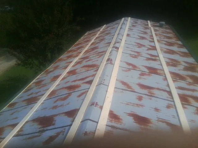 Rusted metal roof panels with new wood purlins before replacement — Storm Damage Roof Repair in Port Reading by Roofing Brothers