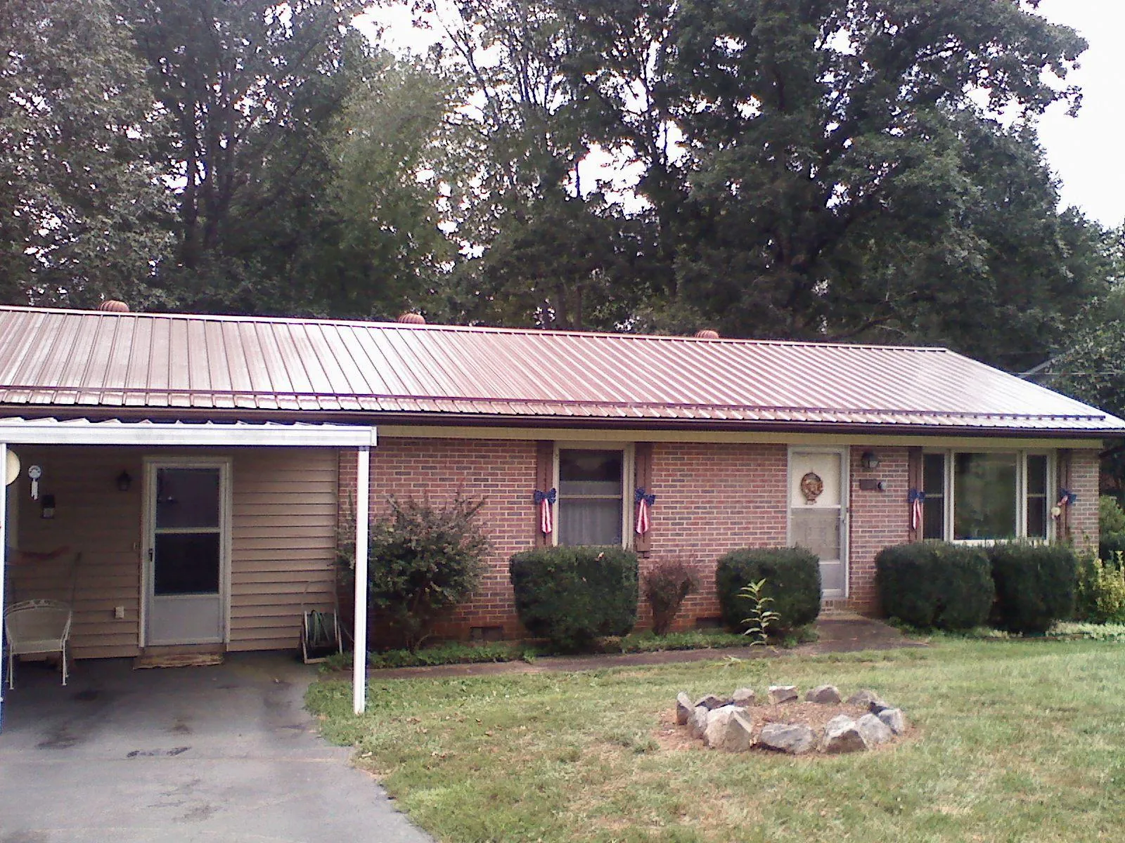 Bronze metal roof and carport on a brick ranch home — Roof Repair work by our crew in Port Reading