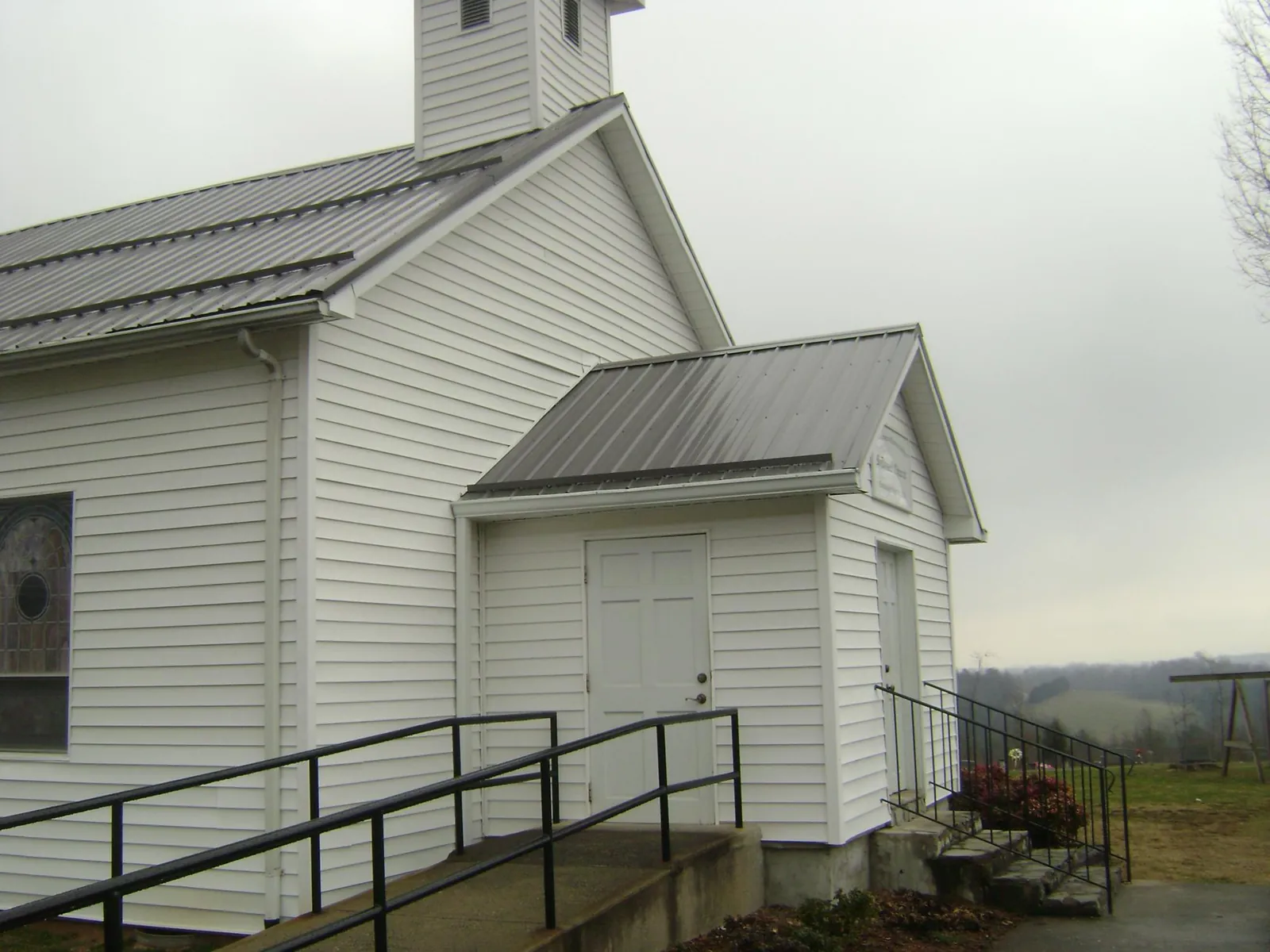 Gray metal roof on a white clapboard church with a steeple in Port Reading